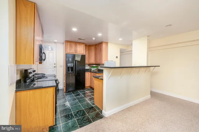 a view of a kitchen with a sink and a refrigerator