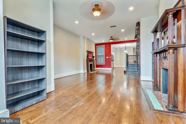 a view of a hallway with wooden floor and staircase