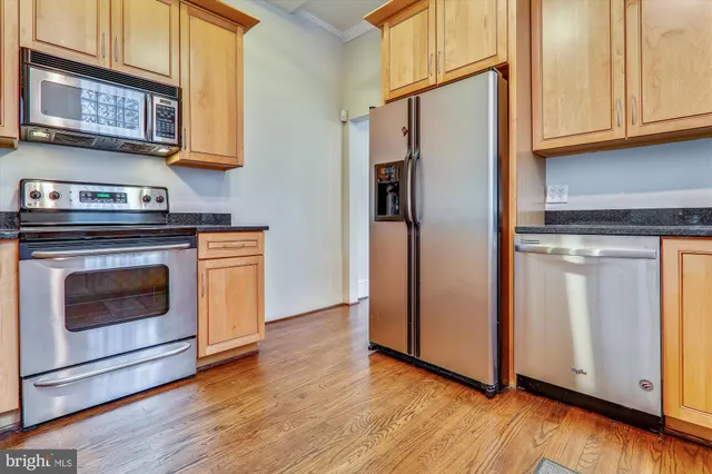a kitchen with stainless steel appliances granite countertop a refrigerator and a stove top oven