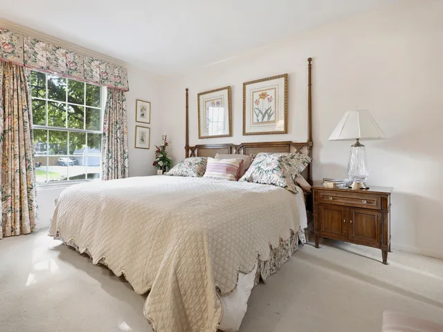 a large bed sitting in a bedroom next to a window