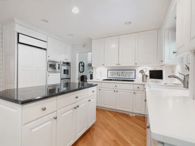 a kitchen with granite countertop cabinets stainless steel appliances and a sink