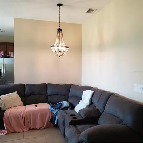 a living room with furniture a couch and chandelier