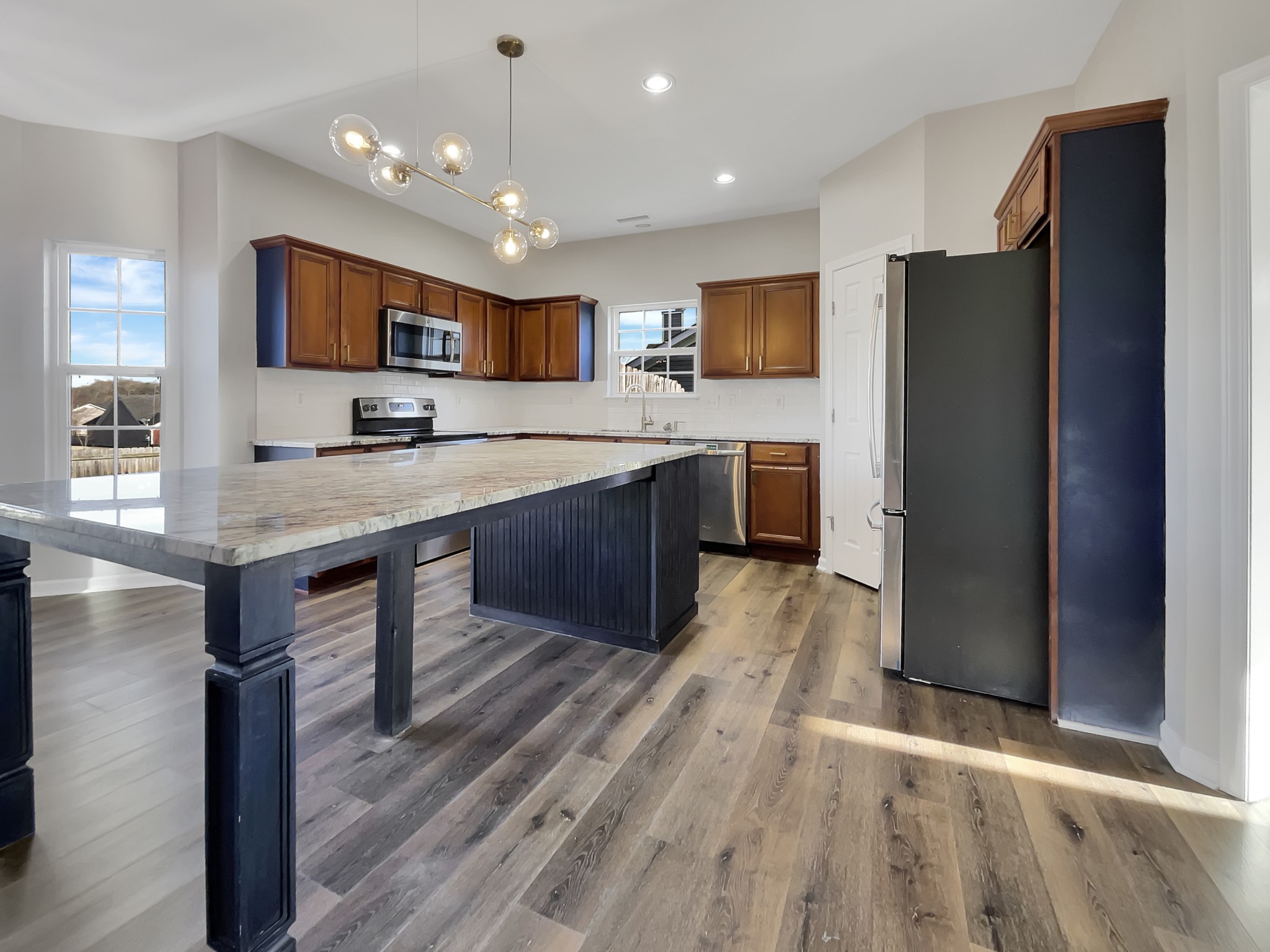 2033 Red Jacket Trace Spring Hill, TN 37174 - Photo 8 of 20 a kitchen with stainless steel appliances granite countertop a refrigerator a sink dishwasher a stove and white countertops with wooden floor