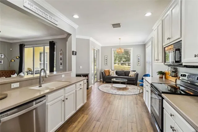 a large kitchen with stainless steel appliances granite countertop a lot of counter space and wooden floors