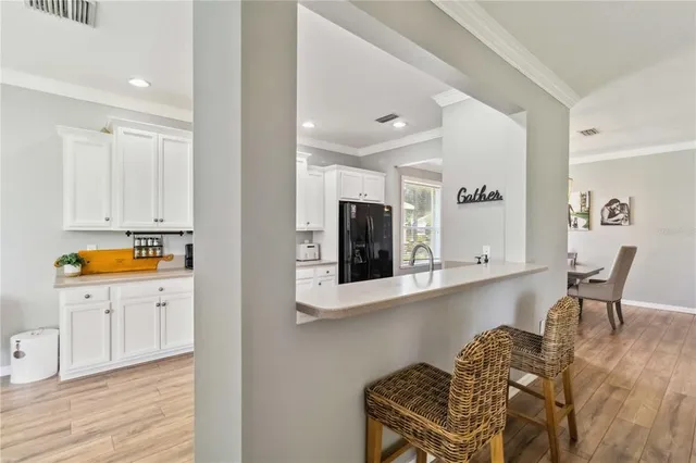 a kitchen with stainless steel appliances kitchen island granite countertop a table and chairs in it
