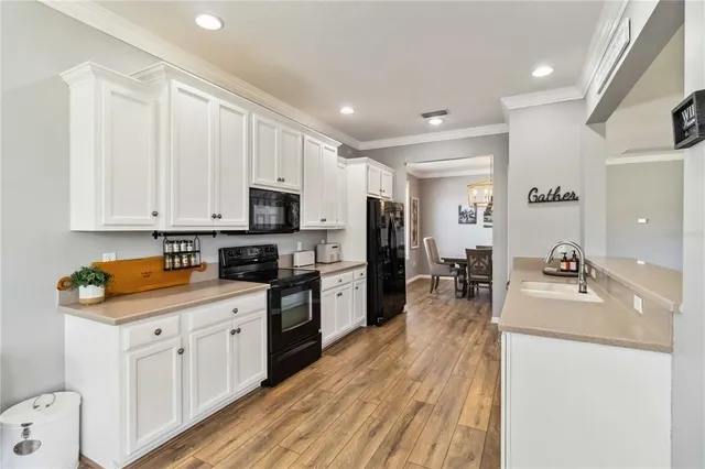 a large kitchen with stainless steel appliances granite countertop a lot of counter space and wooden floor