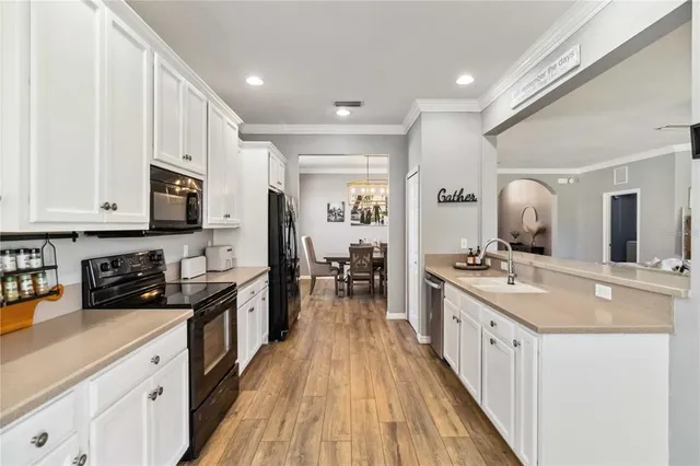a large kitchen with stainless steel appliances granite countertop a lot of counter space and wooden floor
