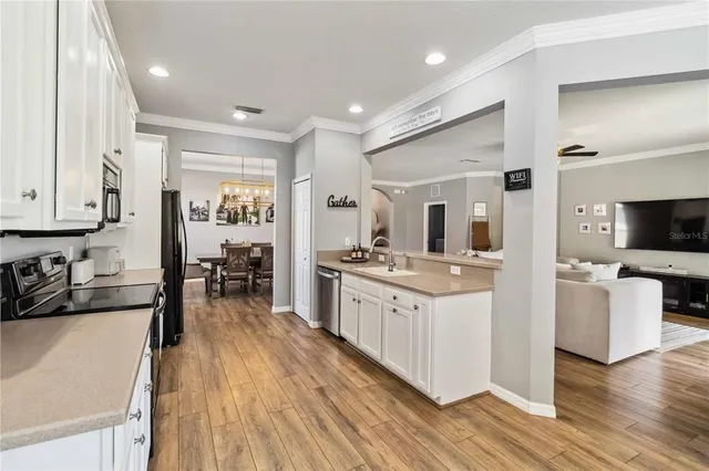 a large kitchen with a lot of counter space a sink and stainless steel appliances
