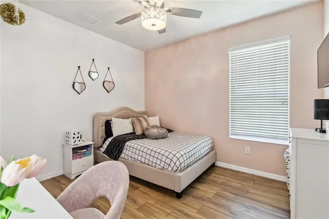 a bedroom with a bed a flat screen tv and a chandelier