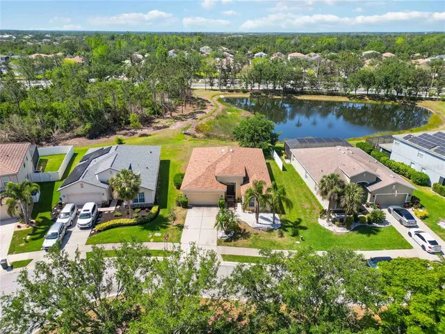 an aerial view of a house with a garden and lake view