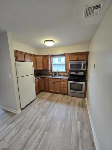 a kitchen with wooden floors and appliances