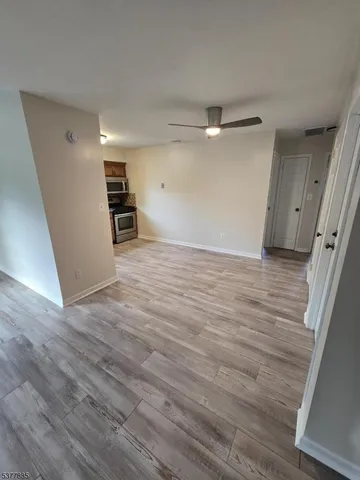 a view of empty room with wooden floor