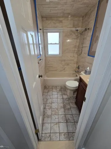 a bathroom with a sink a toilet a mirror and shower