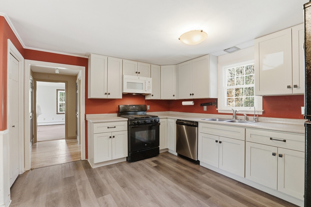 254 Ash Swamp Road Newmarket, NH 03857 - Photo 3 of 30 a kitchen with stainless steel appliances granite countertop a stove a sink and a refrigerator