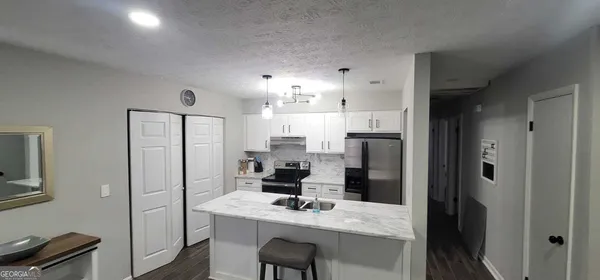 a kitchen with a refrigerator and a stove top oven