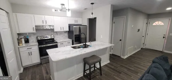 a kitchen with refrigerator and cabinets