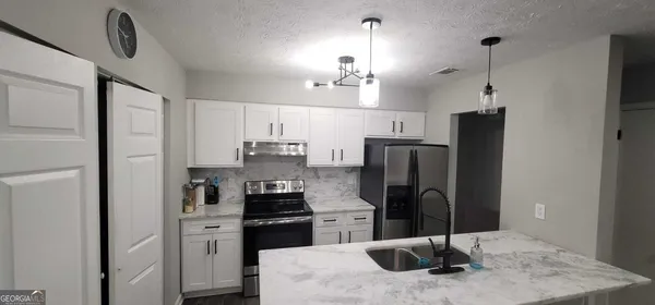 a kitchen with stainless steel appliances granite countertop a refrigerator and a sink
