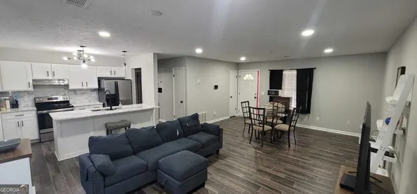 a living room with furniture and a wooden floor