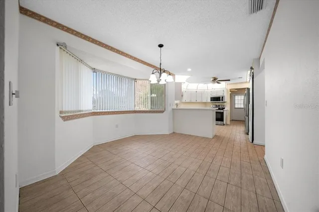 a kitchen with stainless steel appliances and chandelier