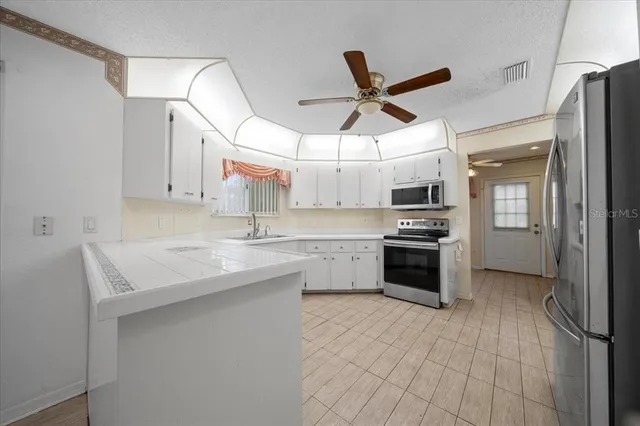 an empty room with windows and fan