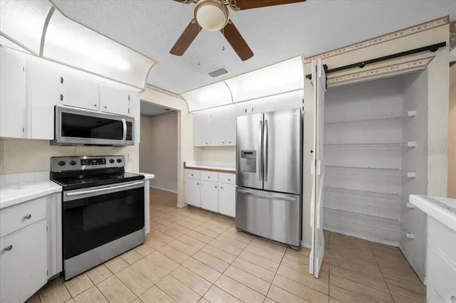 a hallway with white cabinets and sink