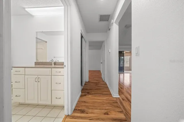 a view of a room with a ceiling fan and wooden floor