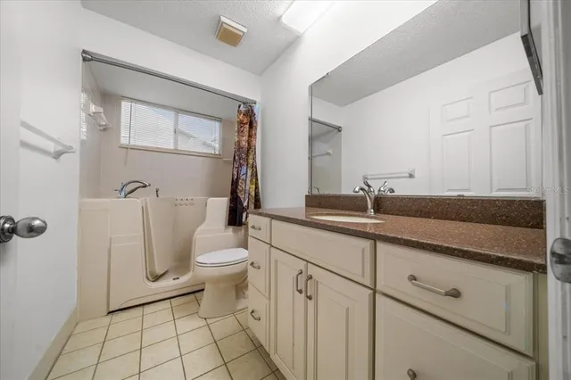 a view of a big room with wooden floor and a chandelier fan