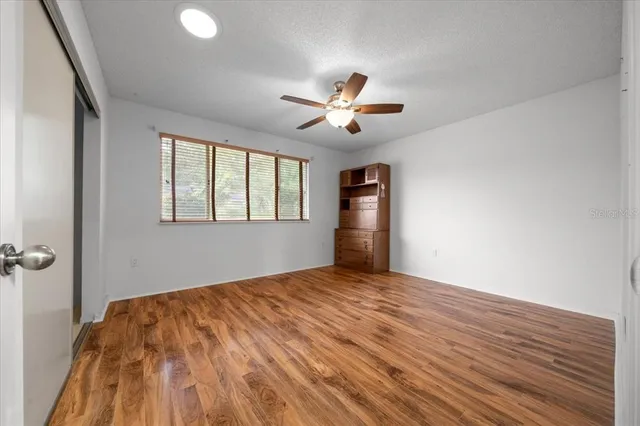 a view of an empty room with closet and a bathroom
