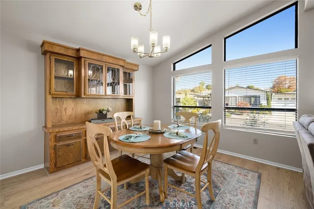 a dining room with furniture a chandelier and wooden floor