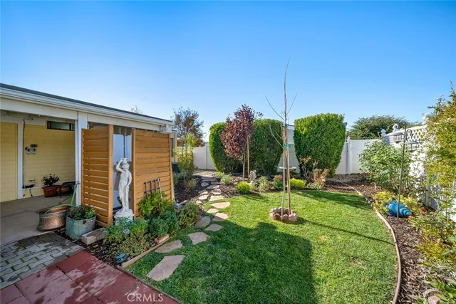 a view of a backyard with couches plants and large tree
