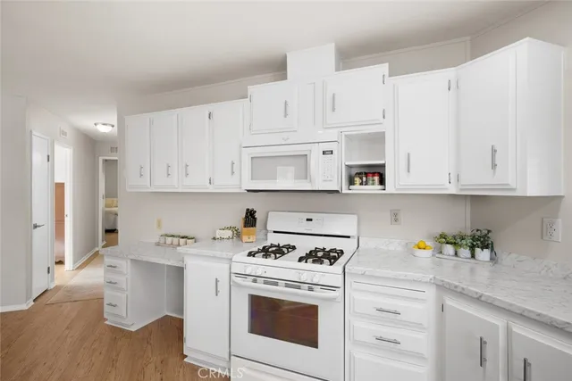 a kitchen with white cabinets and white appliances