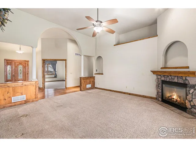 an empty room with wooden floor chandelier and entryway