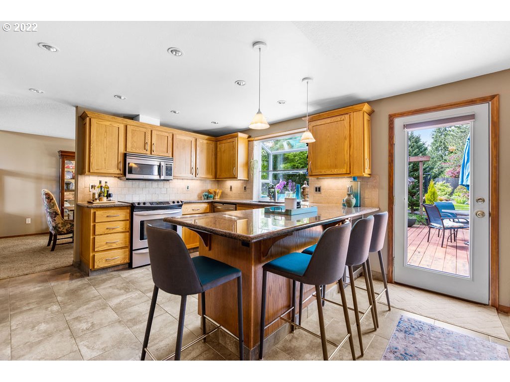 3720 Northeast 160th Street Ridgefield, WA 98642 - Photo 11 of 32 a open kitchen with stainless steel appliances granite countertop a table chairs and a refrigerator