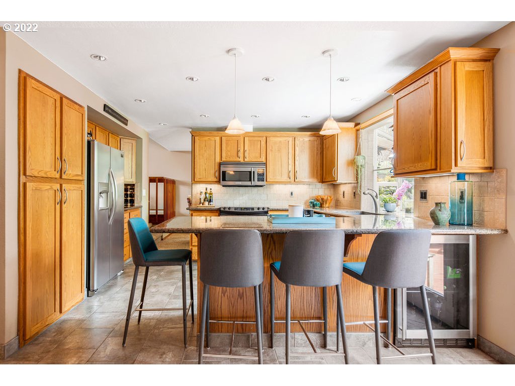 3720 Northeast 160th Street Ridgefield, WA 98642 - Photo 12 of 32 a kitchen with stainless steel appliances granite countertop a table chairs and a window