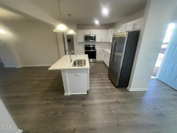 a view of a kitchen with a sink refrigerator and a window