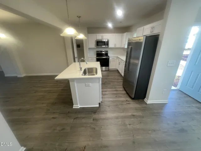 a view of a kitchen with a sink refrigerator and a window