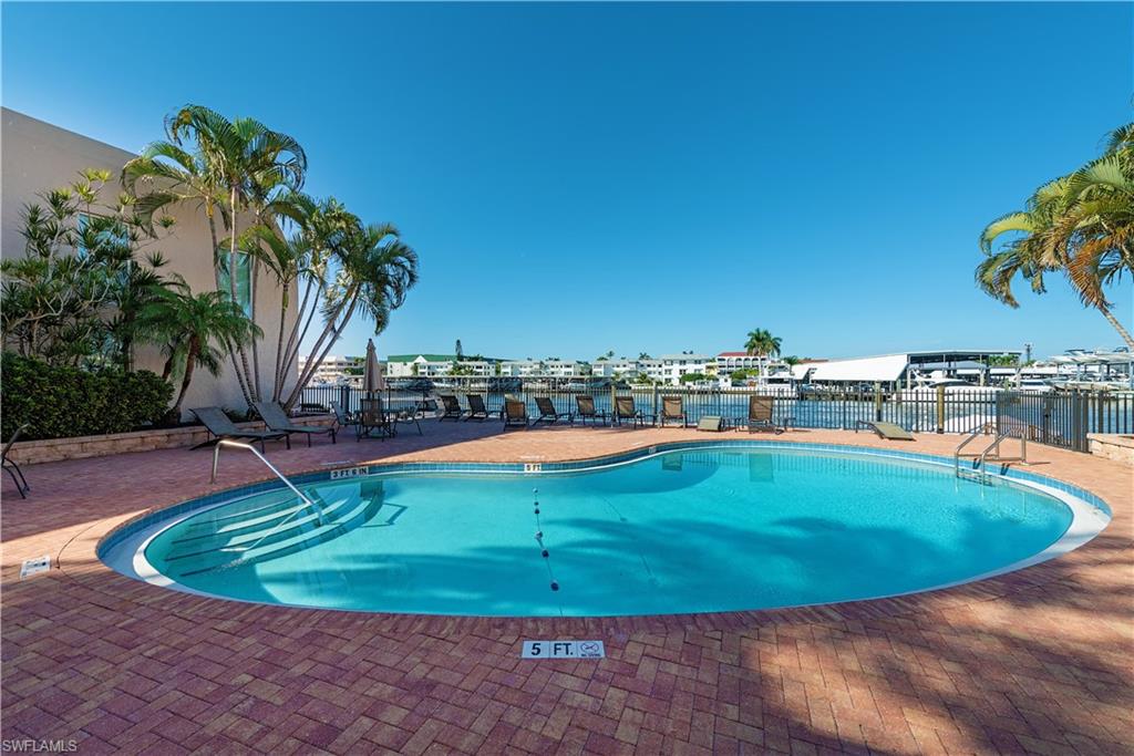 800 River Point Drive, Unit 207 Naples, FL 34102 - Photo 11 of 12 a view of a swimming pool with outdoor seating