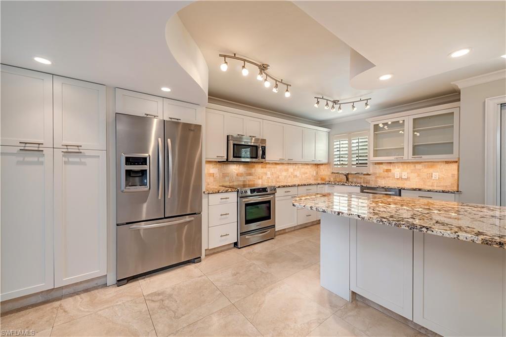 800 River Point Drive, Unit 207 Naples, FL 34102 - Photo 3 of 12 a kitchen with granite countertop stainless steel appliances and refrigerator