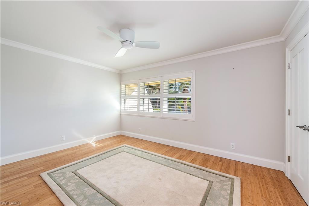 800 River Point Drive, Unit 207 Naples, FL 34102 - Photo 7 of 12 an empty room with wooden floor cabinet and windows