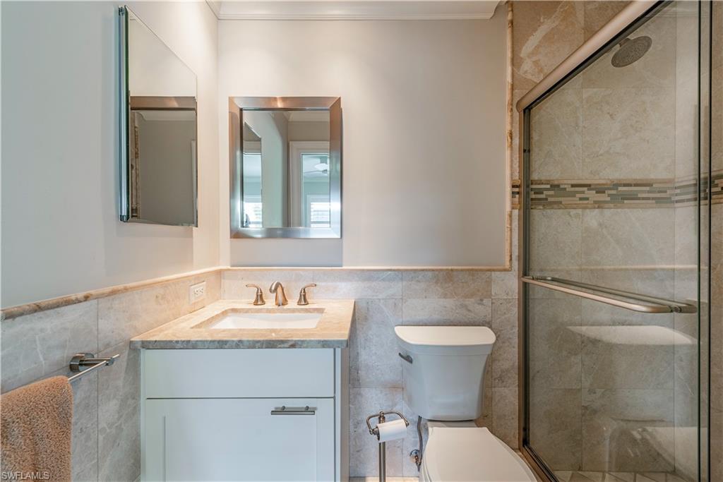 800 River Point Drive, Unit 207 Naples, FL 34102 - Photo 8 of 12 a bathroom with a sink toilet and a mirror