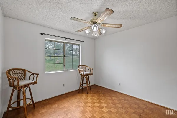 a view of an empty room with a chandelier fan