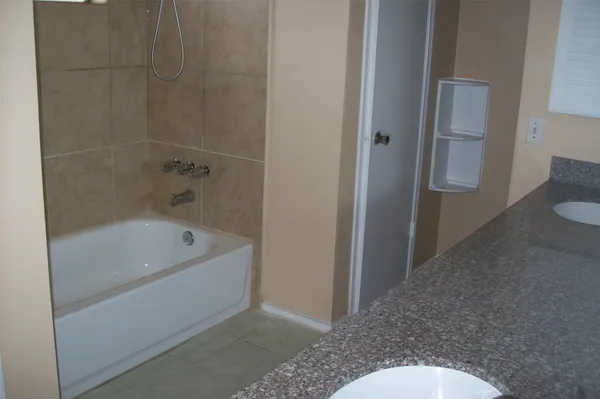 a bathroom with a granite countertop toilet and sink