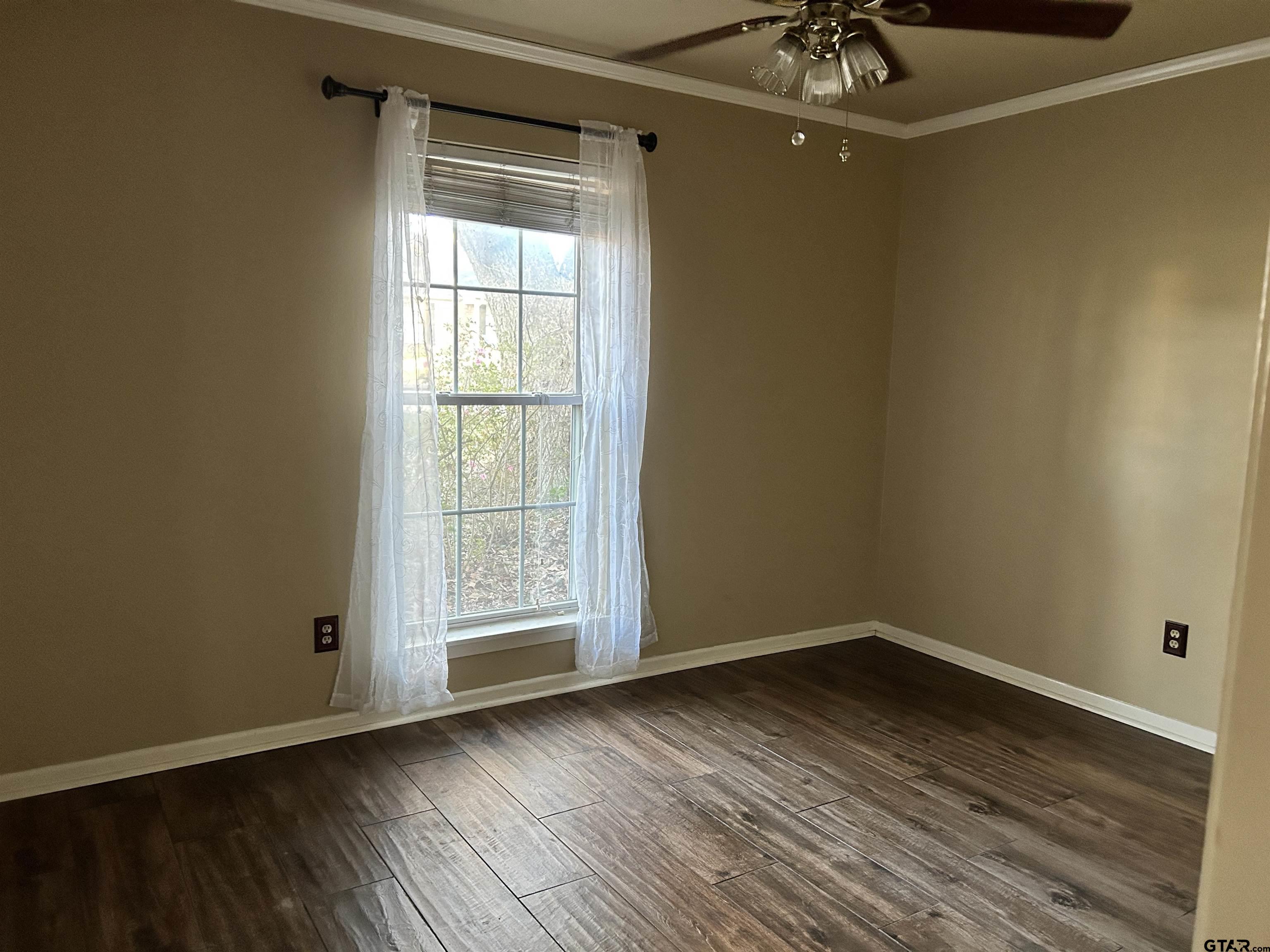 809 David Drive Tyler, TX 75703 - Photo 8 of 18 a view of an empty room with wooden floor and a window