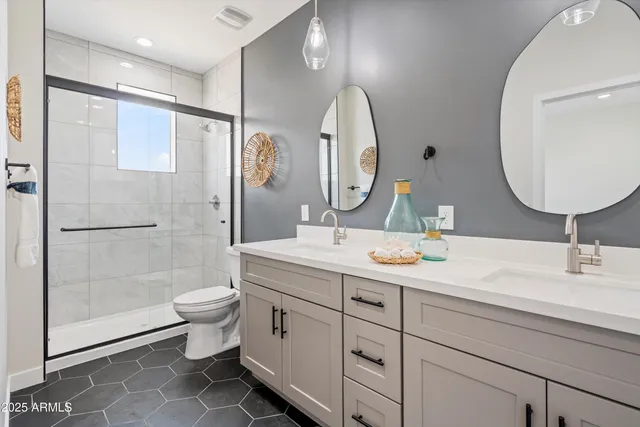 a bathroom with a double vanity sink mirror and toilet