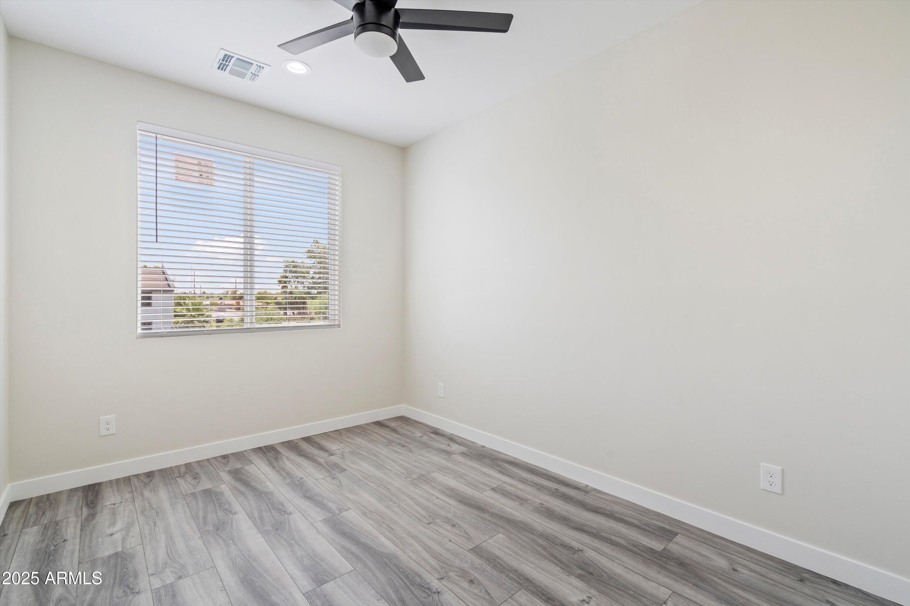 1642 East Monte Vista Road, Unit 1 Phoenix, AZ 85006 - Photo 23 of 34 an empty room with a window and a ceiling fan