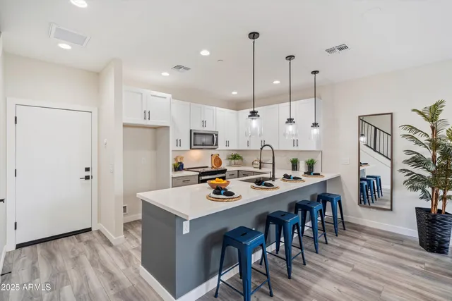 a kitchen with stainless steel appliances a table and chairs in it