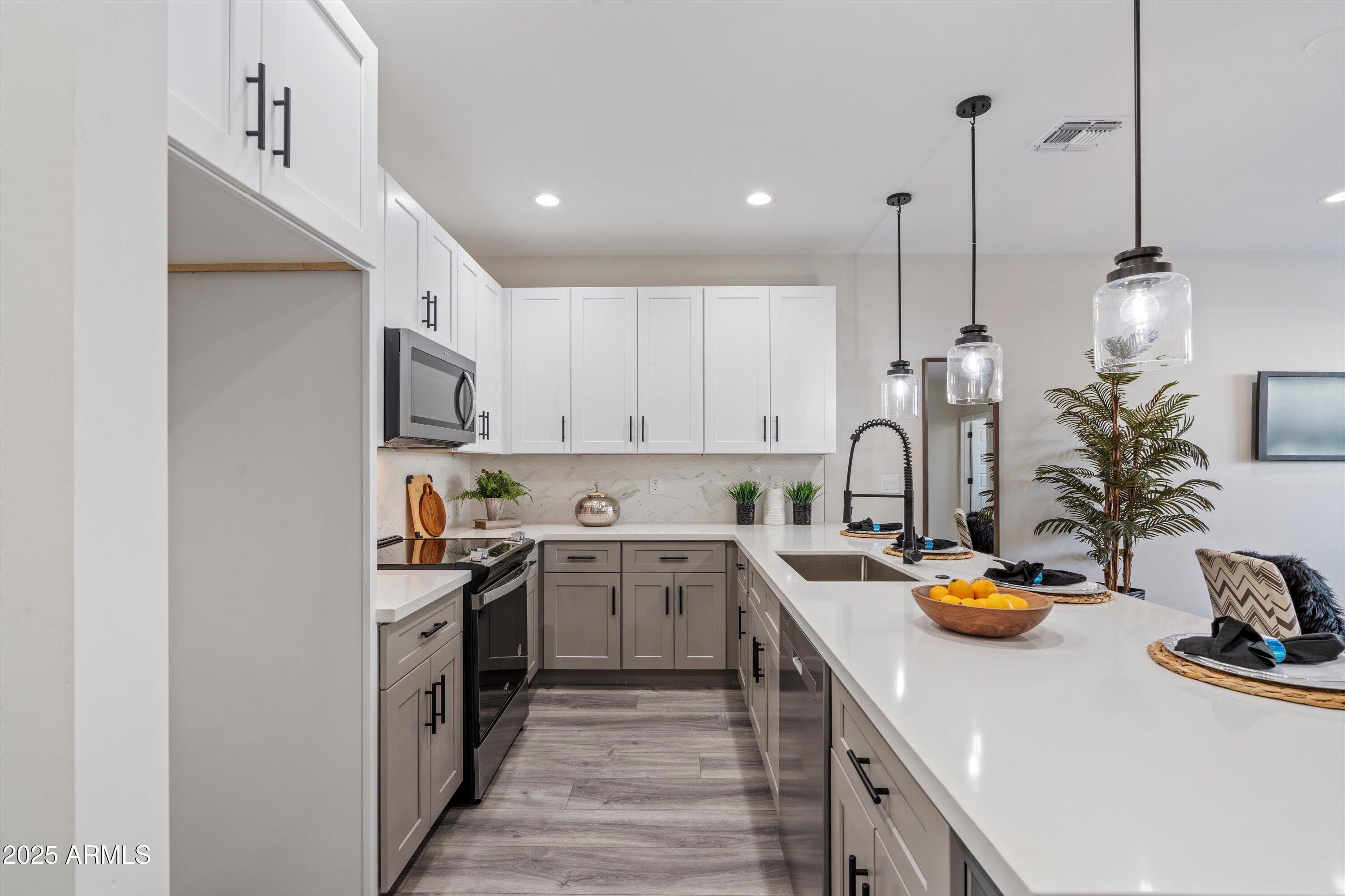 1642 East Monte Vista Road, Unit 1 Phoenix, AZ 85006 - Photo 8 of 34 a kitchen with stainless steel appliances granite countertop a sink dishwasher a stove and a refrigerator with wooden floor