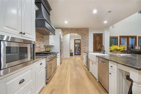 a kitchen with stainless steel appliances granite countertop a table and chairs