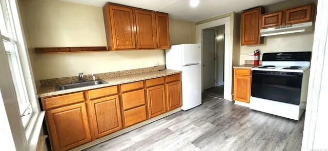 a kitchen with stainless steel appliances granite countertop a stove a sink and a refrigerator