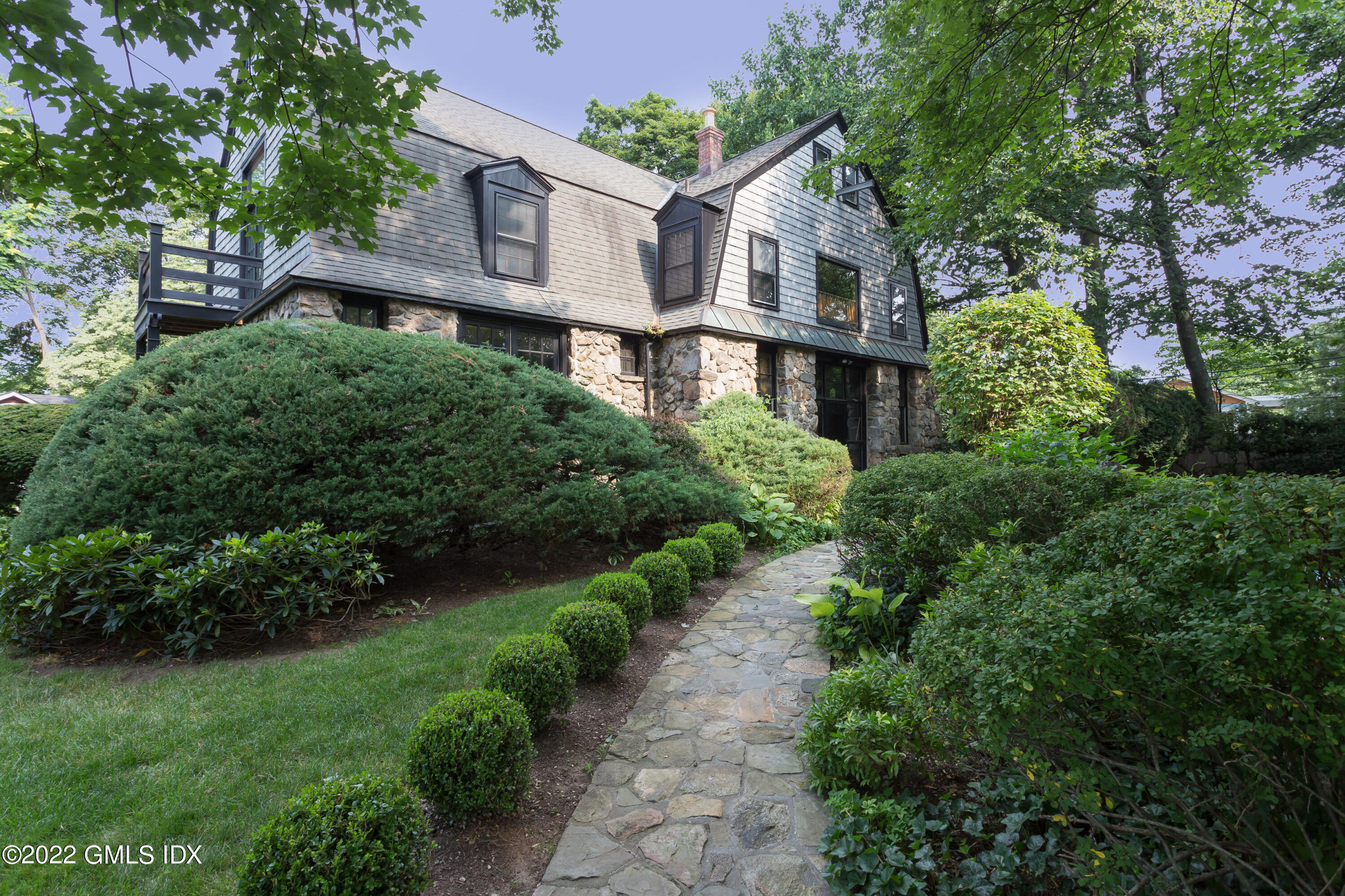 a front view of a house with a yard and trees